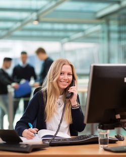 Eine kaufmännische Auszubildende führt ein Telefonat